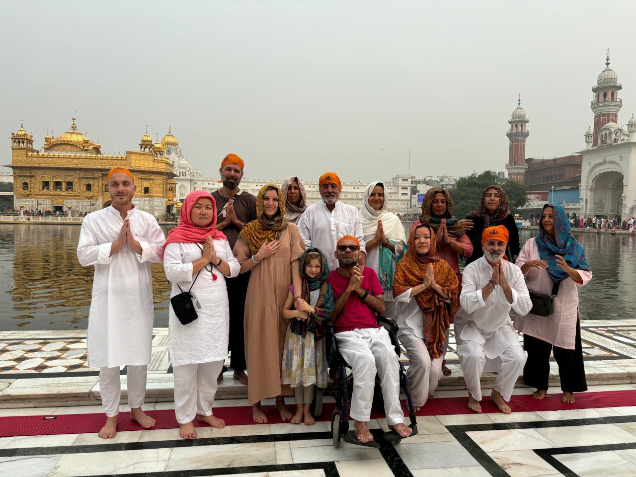 Grupo de viajeros en el Templo Dorado, Amritsar, mostrando respeto y oración.