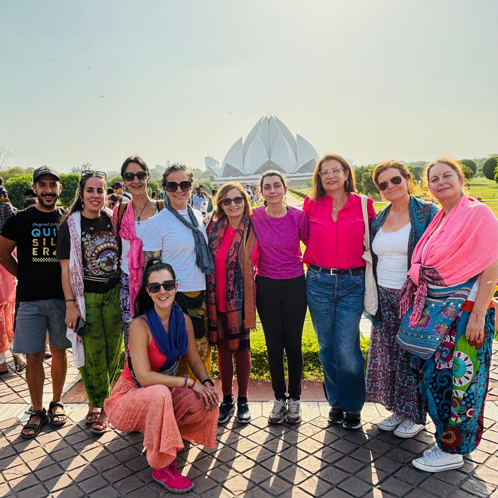 Grupo de viajeros posando frente al Templo del Loto en India, disfrutando del turismo.