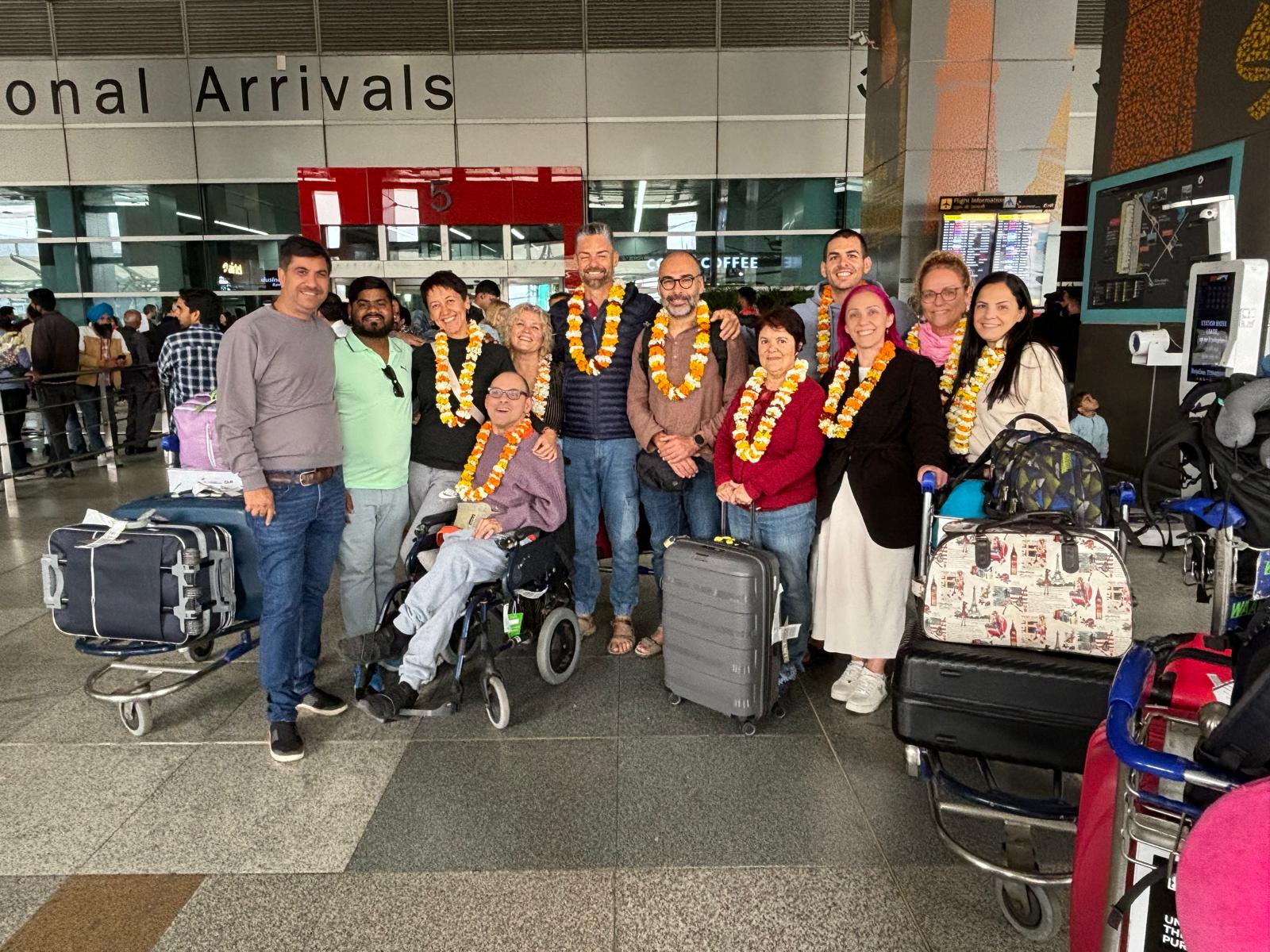 Un grupo de turistas con guirnaldas, recién llegados al aeropuerto, listos para explorar India.