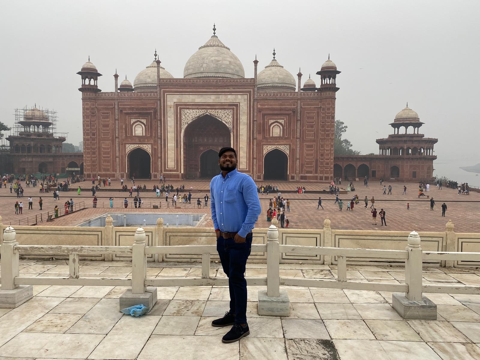 Sachin Rajak dando una explicación histórica junto al magnífico Taj Mahal en Agra.