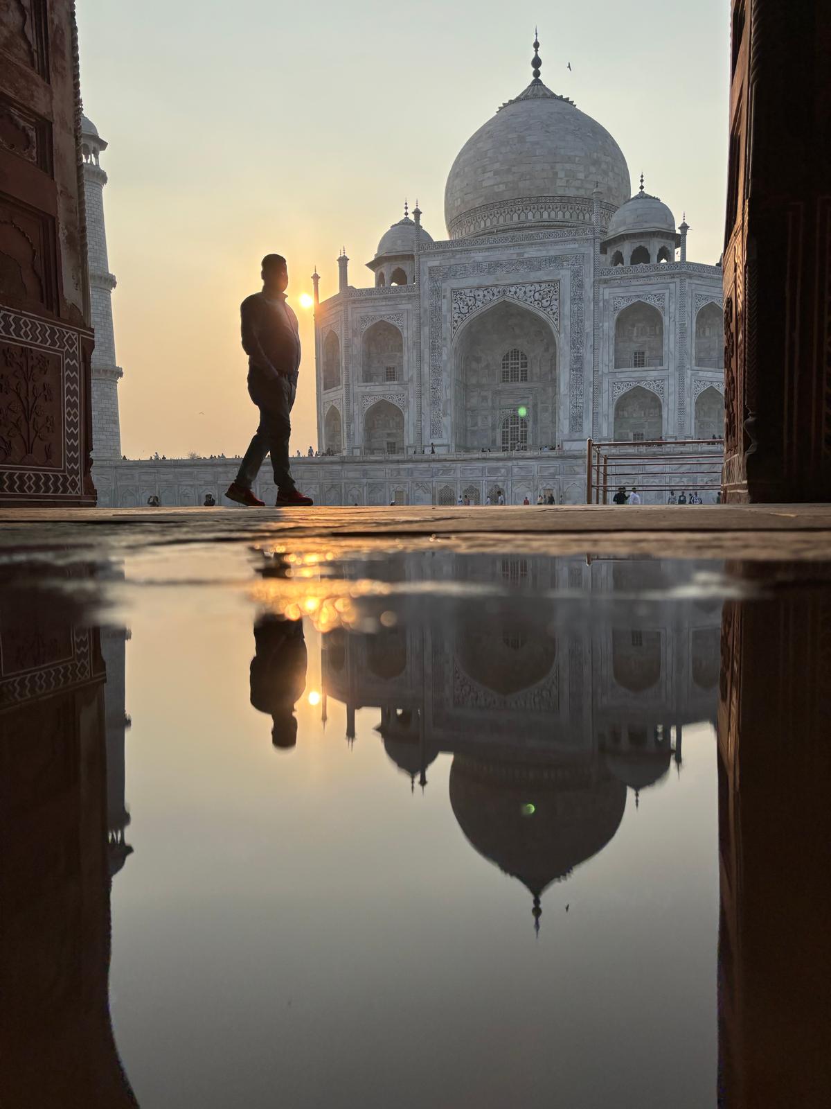 Sachin mostrando el majestuoso Taj Mahal al atardecer, con su reflejo en las aguas del estanque.